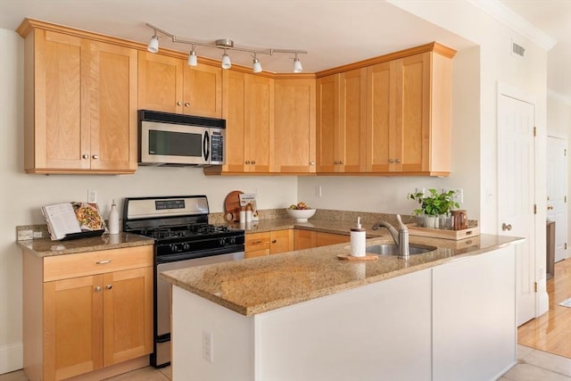 kitchen with light tile patterned floors, light stone countertops, light brown cabinets, and appliances with stainless steel finishes