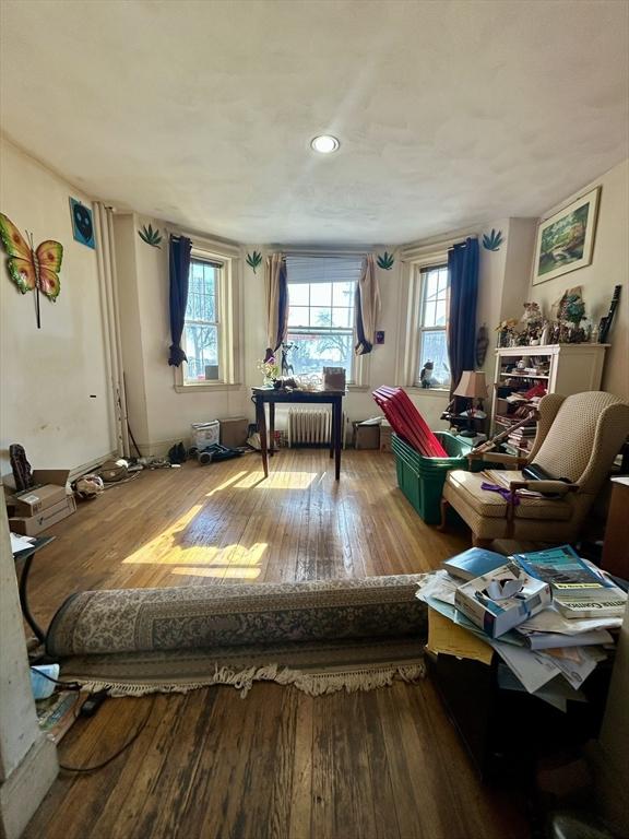 living area with radiator and wood-type flooring