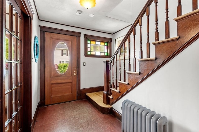 41 Bancroft St, Watertown, MA 02472 - foyer entrance featuring radiator heating unit, baseboards, stairs, and crown molding