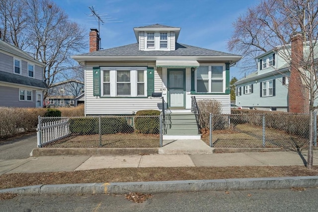 bungalow featuring a fenced front yard, a chimney, and roof with shingles