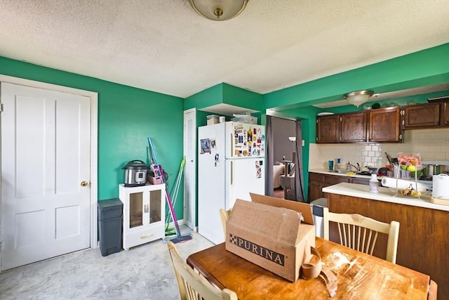 101 Cory St, Fall River, MA 02720 - kitchen with freestanding refrigerator, backsplash, light countertops, dark brown cabinets, and a sink