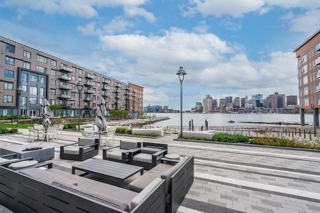 view of home's community with an outdoor living space, a patio area, a water view, and a city view