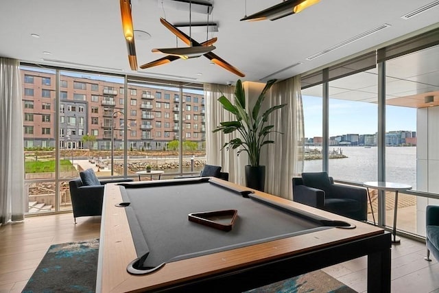 game room with billiards, wood finished floors, and floor to ceiling windows