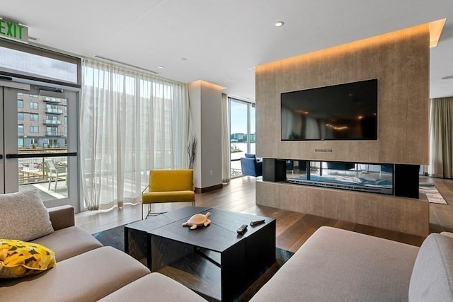 living room with a wall of windows, recessed lighting, and wood finished floors