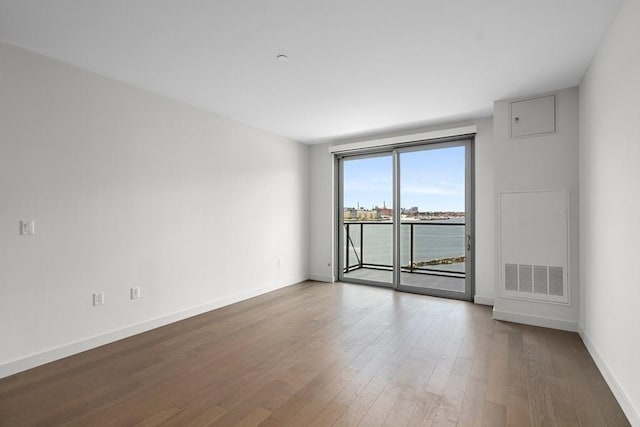 unfurnished room with baseboards and wood finished floors