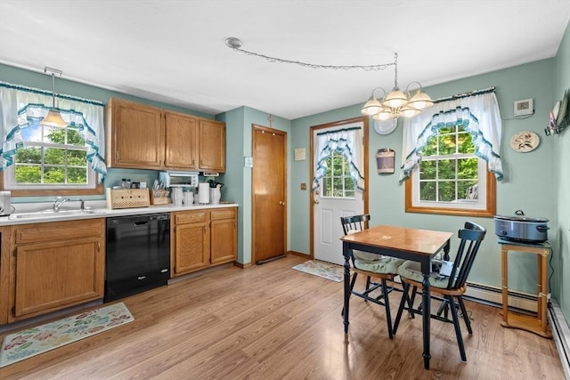 kitchen featuring a sink, light wood-style floors, light countertops, dishwasher, and decorative light fixtures