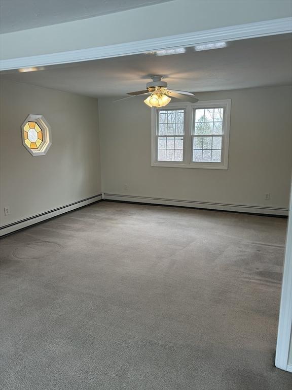 carpeted empty room with a ceiling fan