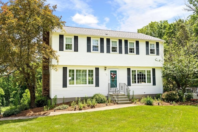 colonial-style house featuring a front yard