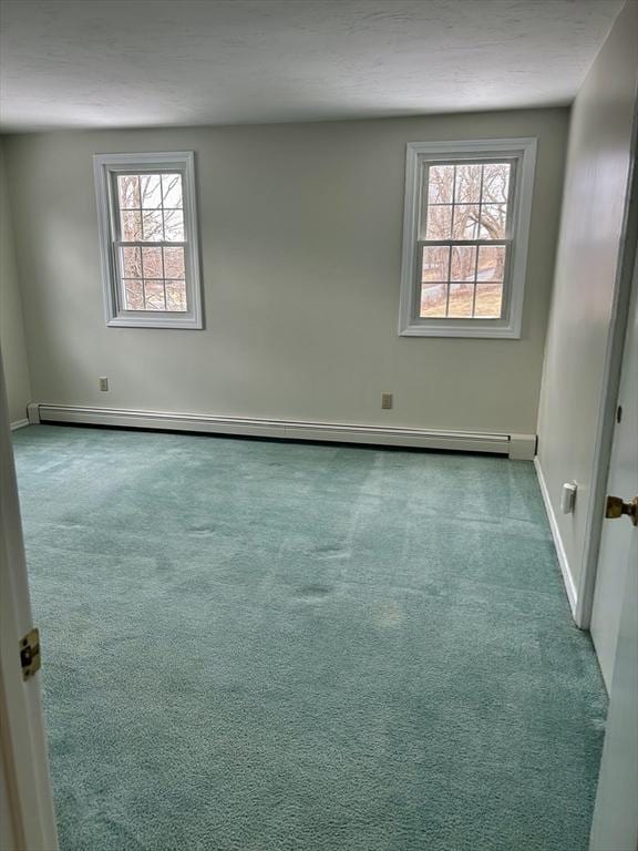 spare room with carpet floors, a baseboard radiator, and baseboards