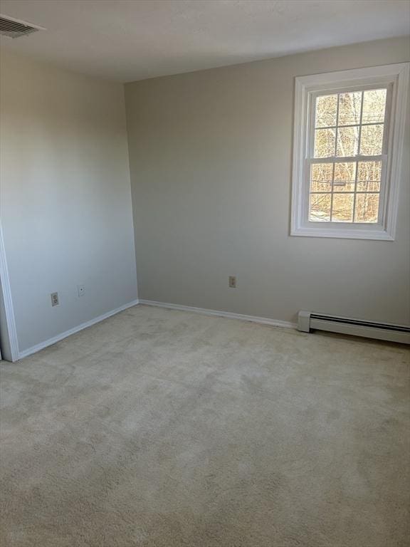 empty room featuring light carpet, baseboards, visible vents, and baseboard heating