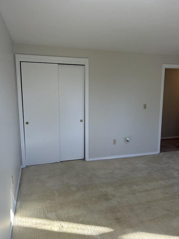 unfurnished bedroom featuring a closet, carpet flooring, and baseboards