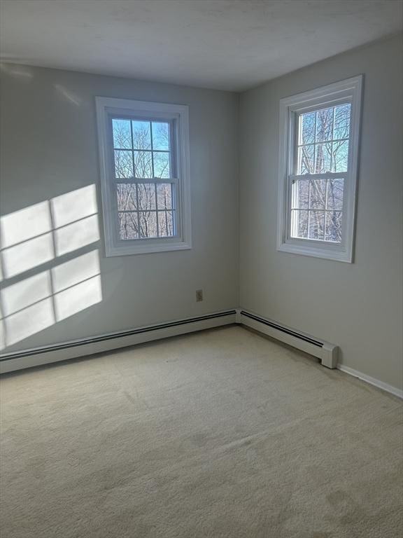 carpeted spare room featuring baseboards and a healthy amount of sunlight