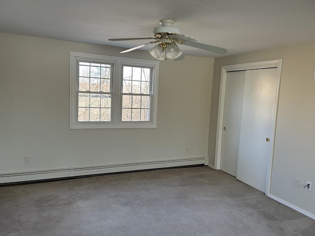 unfurnished bedroom with carpet floors, a baseboard radiator, ceiling fan, and a closet