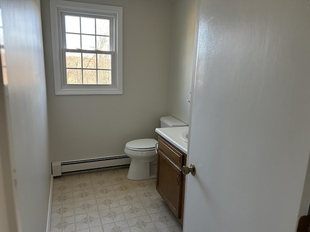 bathroom with a baseboard radiator, vanity, toilet, and tile patterned floors