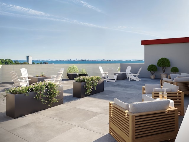 view of patio / terrace featuring a water view and an outdoor living space with a fire pit