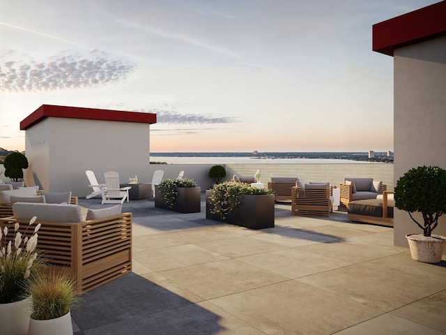 patio terrace at dusk with a water view and an outdoor living space