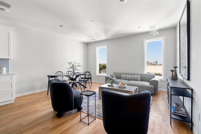 living room with light wood-type flooring and plenty of natural light