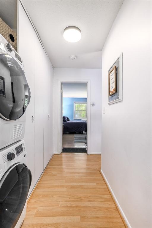 120 Litchfield Pines Dr Unit A, Leominster, MA 01453 - washroom featuring estacked washer and dryer, light wood finished floors, and baseboards