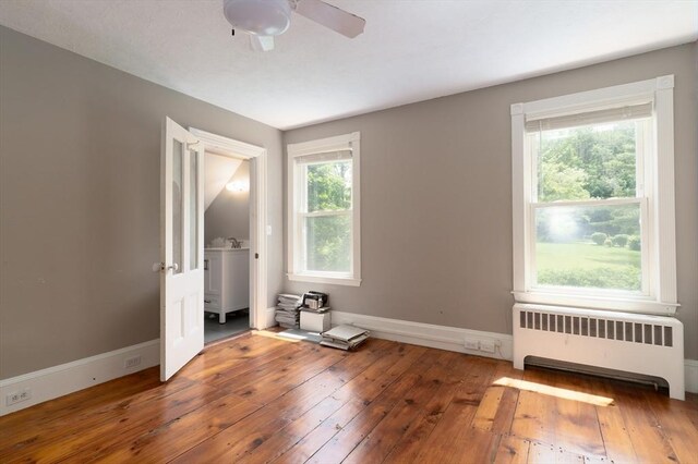 1 Commonwealth Ave, Sturbridge, MA 01518 - spare room with radiator heating unit, hardwood / wood-style flooring, and ceiling fan