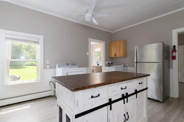 1 Commonwealth Ave, Sturbridge, MA 01518 - kitchen featuring freestanding refrigerator, baseboard heating, light wood finished floors, dark countertops, and crown molding