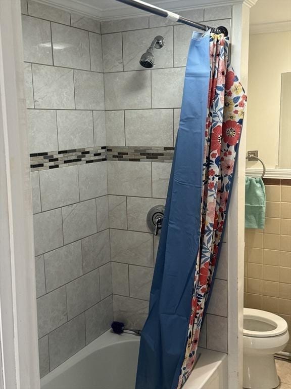 bathroom with tile walls, shower / bath combo with shower curtain, ornamental molding, and toilet