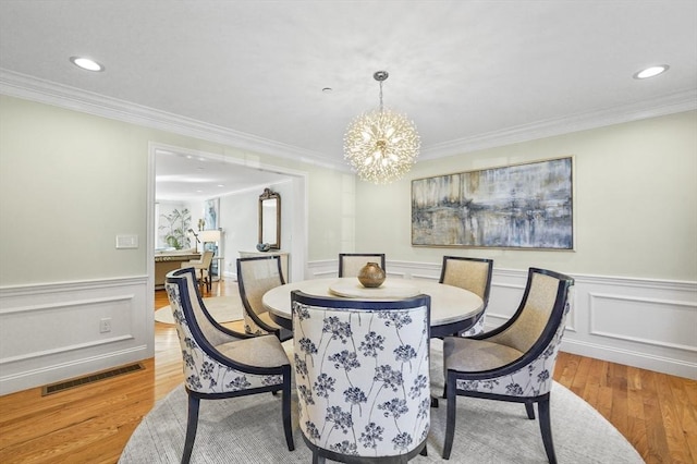 dining area with wood finished floors, recessed lighting, a chandelier, visible vents, and wainscoting