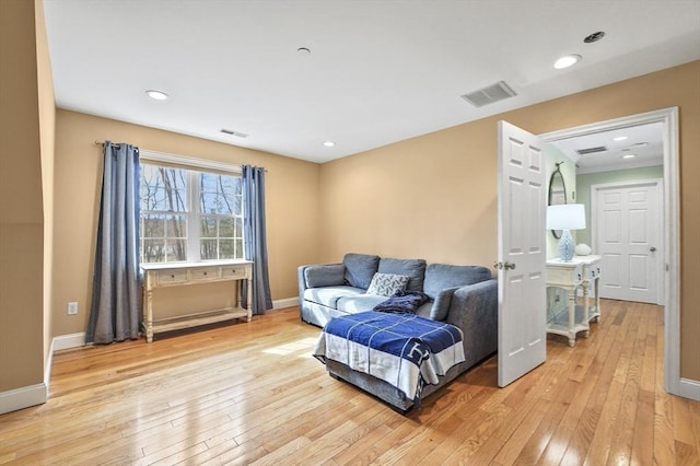 sitting room with baseboards, visible vents, and light wood finished floors