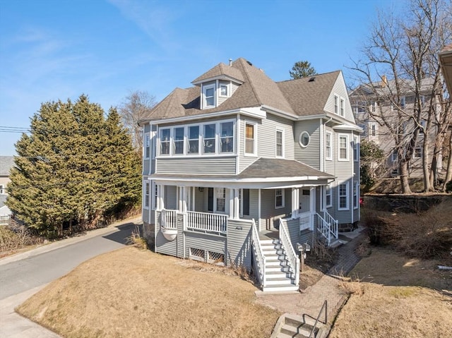 view of front of house featuring stairway, roof with shingles, and a porch