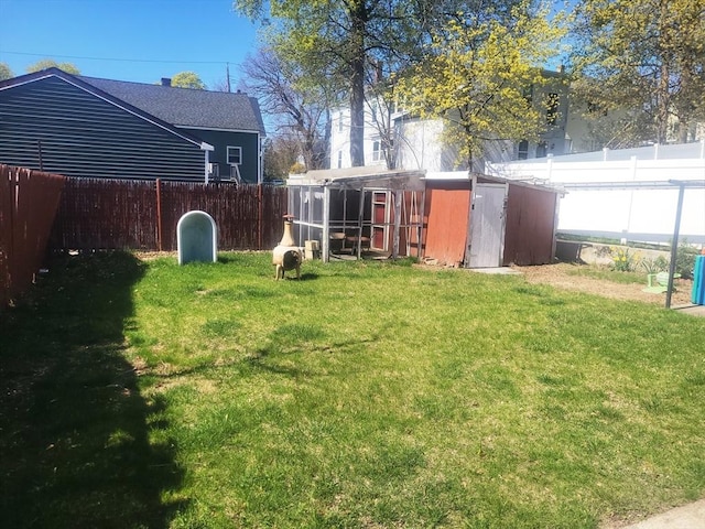 view of yard featuring a fenced backyard, an outdoor structure, and a shed
