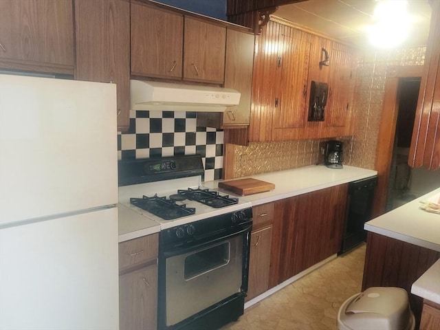 kitchen with tasteful backsplash, dishwasher, gas range oven, wall chimney exhaust hood, and freestanding refrigerator