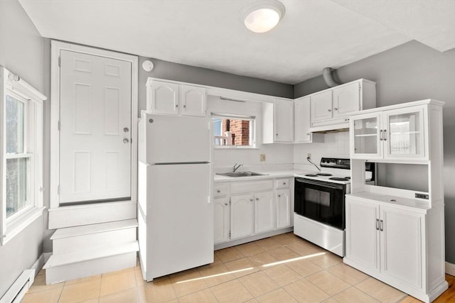 kitchen with a baseboard radiator, electric range, freestanding refrigerator, a sink, and white cabinetry