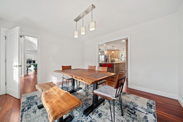 dining space with baseboards and wood finished floors