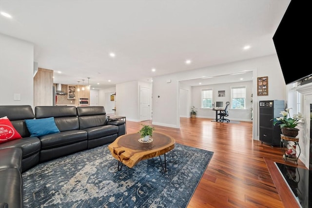 living room with recessed lighting, baseboards, and wood finished floors