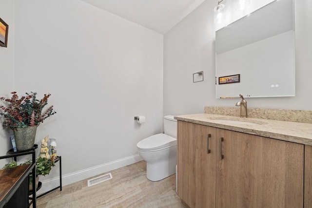 half bathroom with visible vents, baseboards, toilet, and vanity