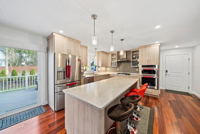 kitchen with stainless steel appliances, a healthy amount of sunlight, wall chimney exhaust hood, and light brown cabinetry