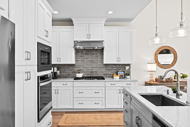 5 Diane Ter Unit 5, Scituate, MA 02066 - kitchen featuring appliances with stainless steel finishes, white cabinets, hanging light fixtures, decorative backsplash, and light stone countertops