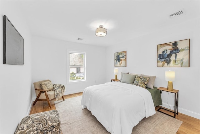 bedroom featuring light wood-style floors and baseboards