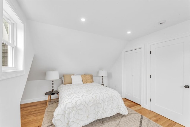 bedroom featuring wood finished floors, lofted ceiling, recessed lighting, and baseboards