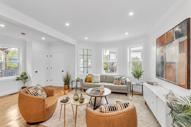 living area featuring healthy amount of natural light, recessed lighting, crown molding, light wood-style flooring, and baseboards