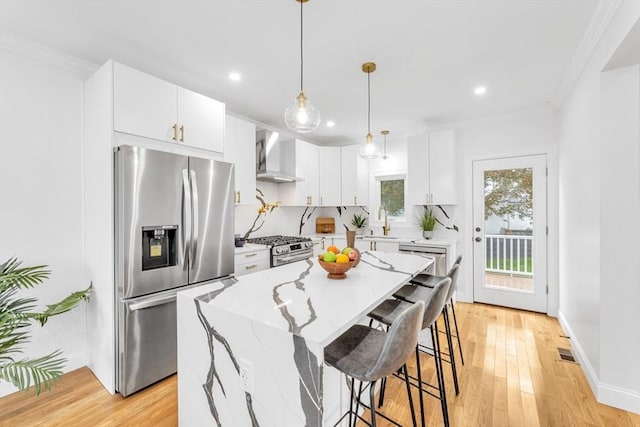 kitchen featuring appliances with stainless steel finishes, wall chimney exhaust hood, a sink, crown molding, and recessed lighting