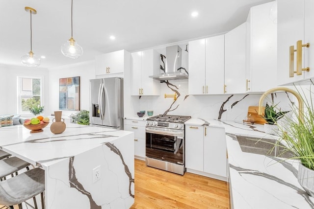 kitchen featuring stainless steel appliances, wall chimney exhaust hood, light wood-style floors, white cabinetry, and recessed lighting