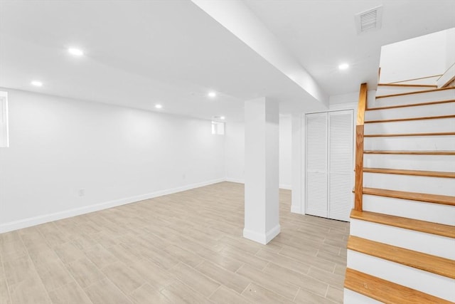finished basement with stairs, baseboards, recessed lighting, and light wood-style flooring