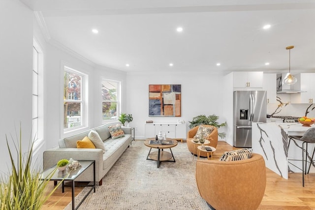 living room with crown molding, recessed lighting, and light wood-style floors