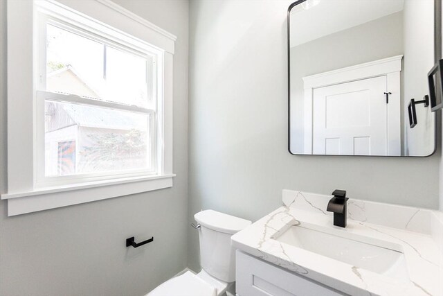 bathroom with toilet, a healthy amount of sunlight, and vanity