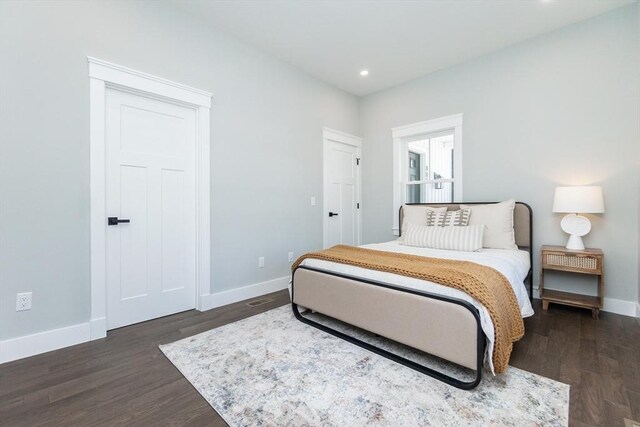 bedroom featuring dark wood finished floors, baseboards, and recessed lighting