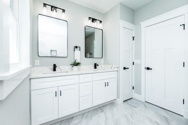 full bathroom with double vanity, a sink, and marble finish floor
