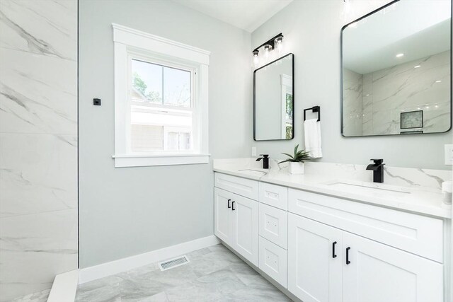 bathroom with a sink, baseboards, visible vents, and marble finish floor
