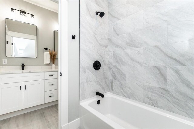 bathroom featuring baseboards, shower / bathing tub combination, and vanity