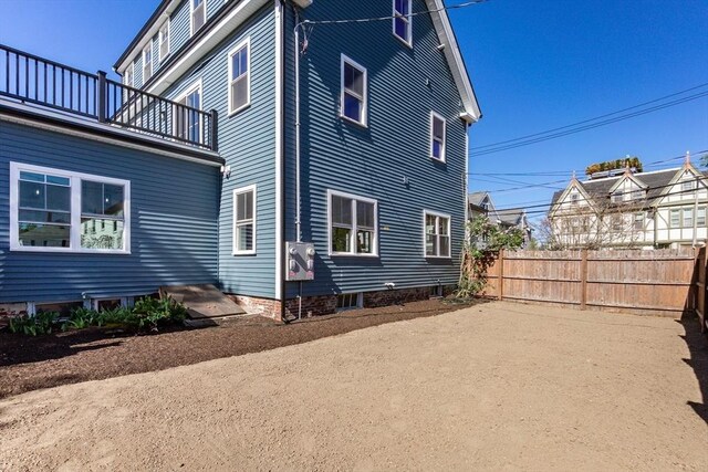 view of property exterior featuring fence and a balcony