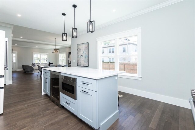 kitchen with light countertops, beverage cooler, open floor plan, stainless steel microwave, and dark wood-style floors